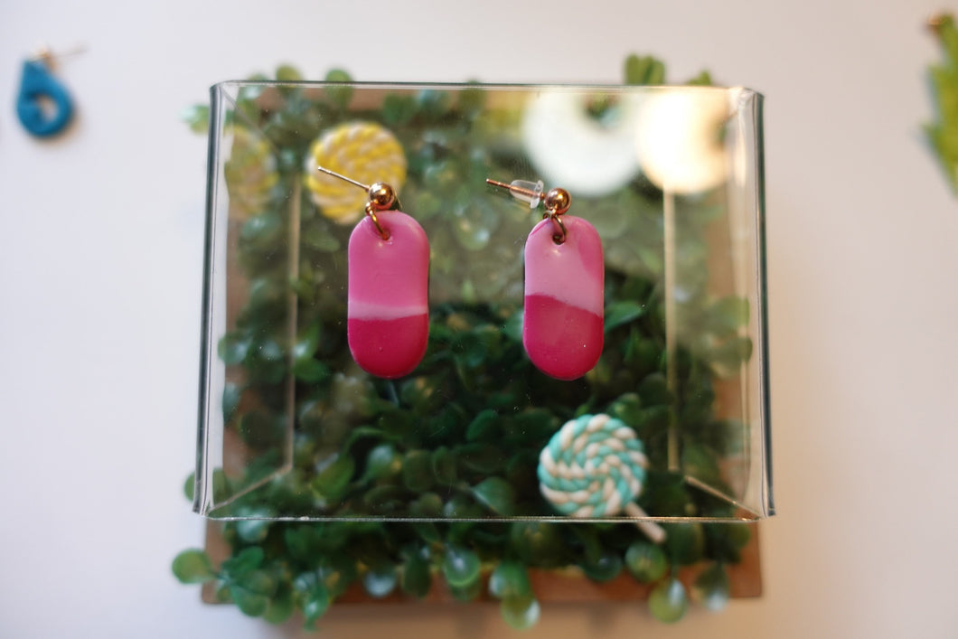 Small pink pill shaped polymer clay earrings